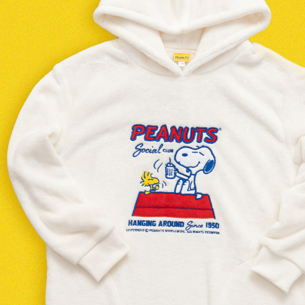Image of a Peanuts® hoodie with a red and blue design. Snoopy and Woodstock are toasting.