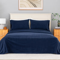 All-Season Microfleece Sheet Set in Navy on a made bed with a cream headboard, front view