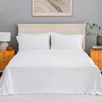 All-Season Microfleece Sheet Set in True White on a made bed with a cream headboard, front view