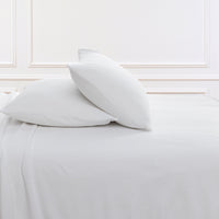All-Season Microfleece Sheet Set pillowcases in True White on a made bed against a white paneled wall