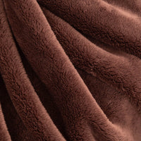 A close-up of draped brown plush faux fur fabric, showing the soft texture and rich color.