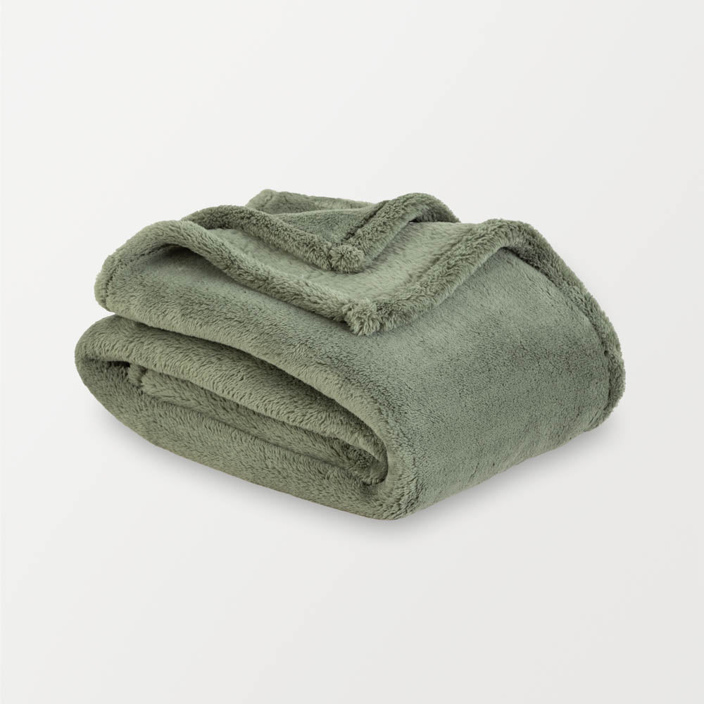 Folded green blanket on a light gray background