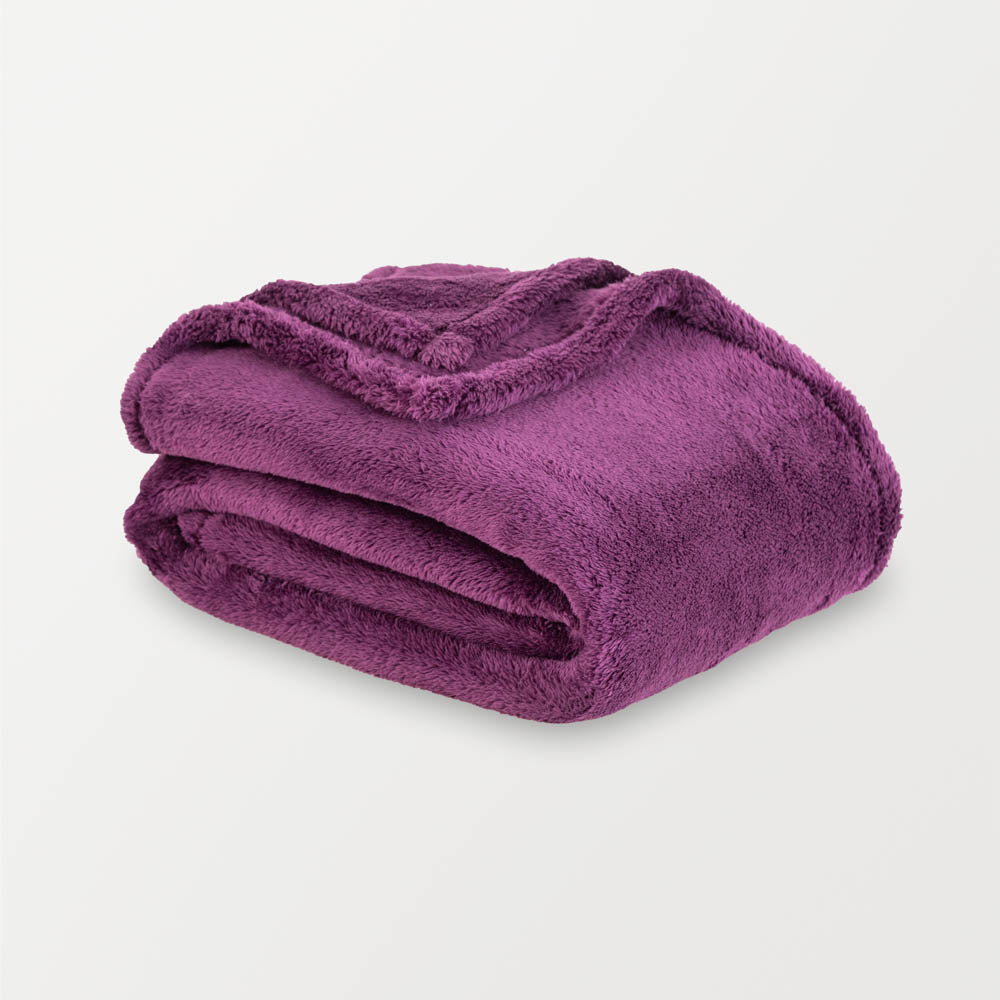 Folded purple blanket on a light gray background