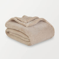 Beige blanket folded on a light gray background