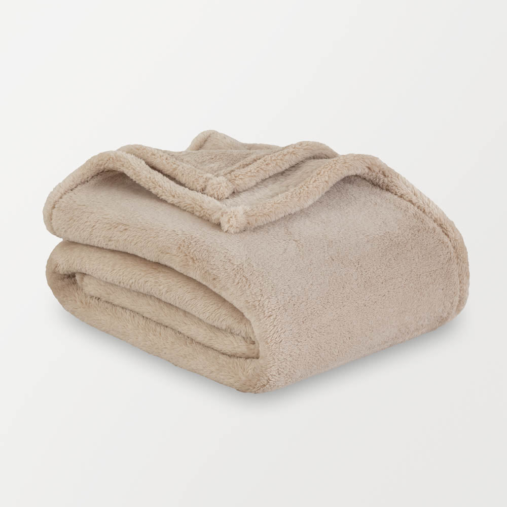 Beige blanket folded on a light gray background