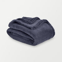 Folded navy blue blanket on a light gray background