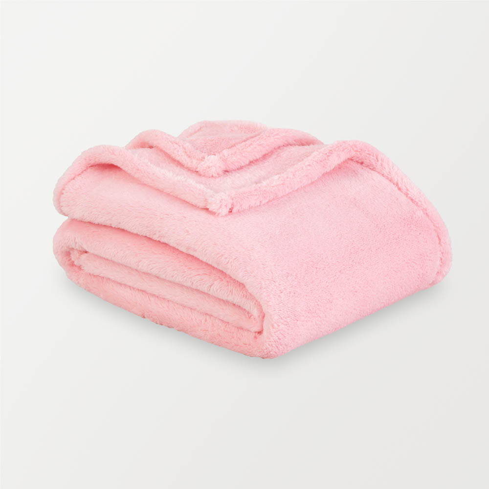 Pink extra fluffy throw folded neatly on a white surface.