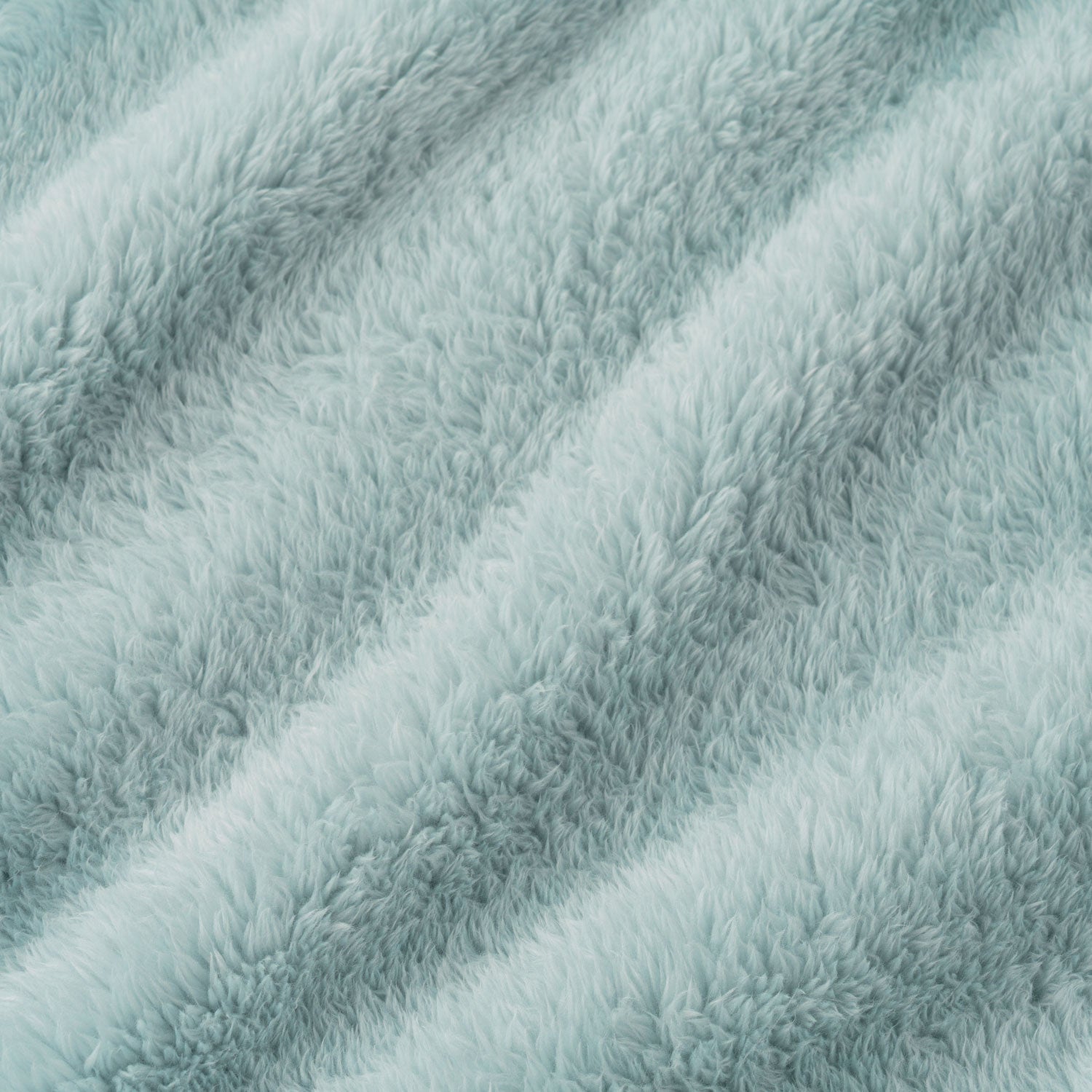 A close-up of a soft, plush faux fur fabric in a pale icy blue color, showing the textured pile and diagonal folds.