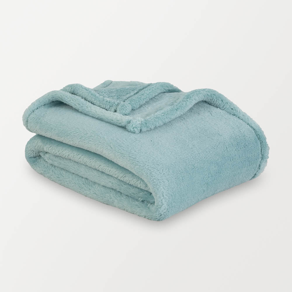 Folded teal blanket on a light gray background