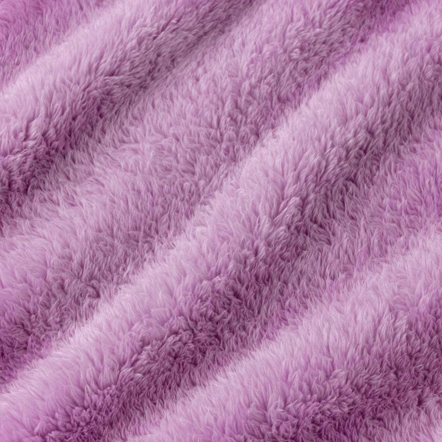 A close-up of a soft, plush faux fur fabric in a dusty lavender-purple color, showing the textured pile and draped folds.