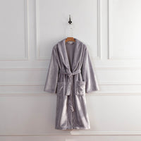 A lilac colored VelvetLoft Robe displayed on a hanger against a white wall.