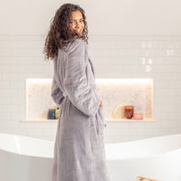 Woman wearing a lilac robe in a bathroom setting