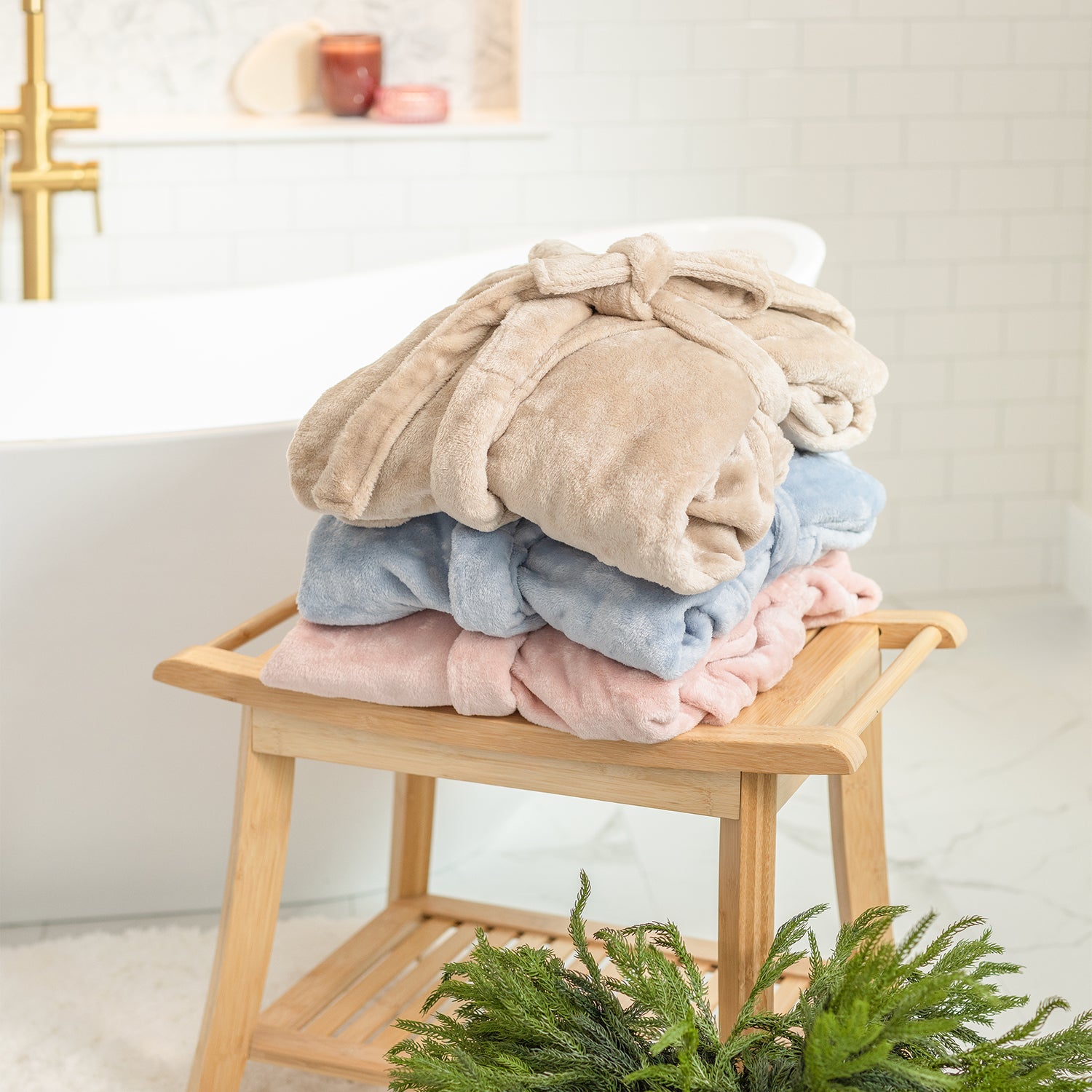 Stack of folded robes on a wooden stool with a neutral background