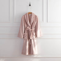 A blush pink VelvetLoft Robe displayed on a hanger against a white wall.