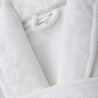 A close-up of the soft, velvety texture of a white VelvetLoft Robe.