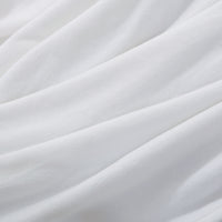 A close up of a white velvety plush throw displaying its silky smooth texture.