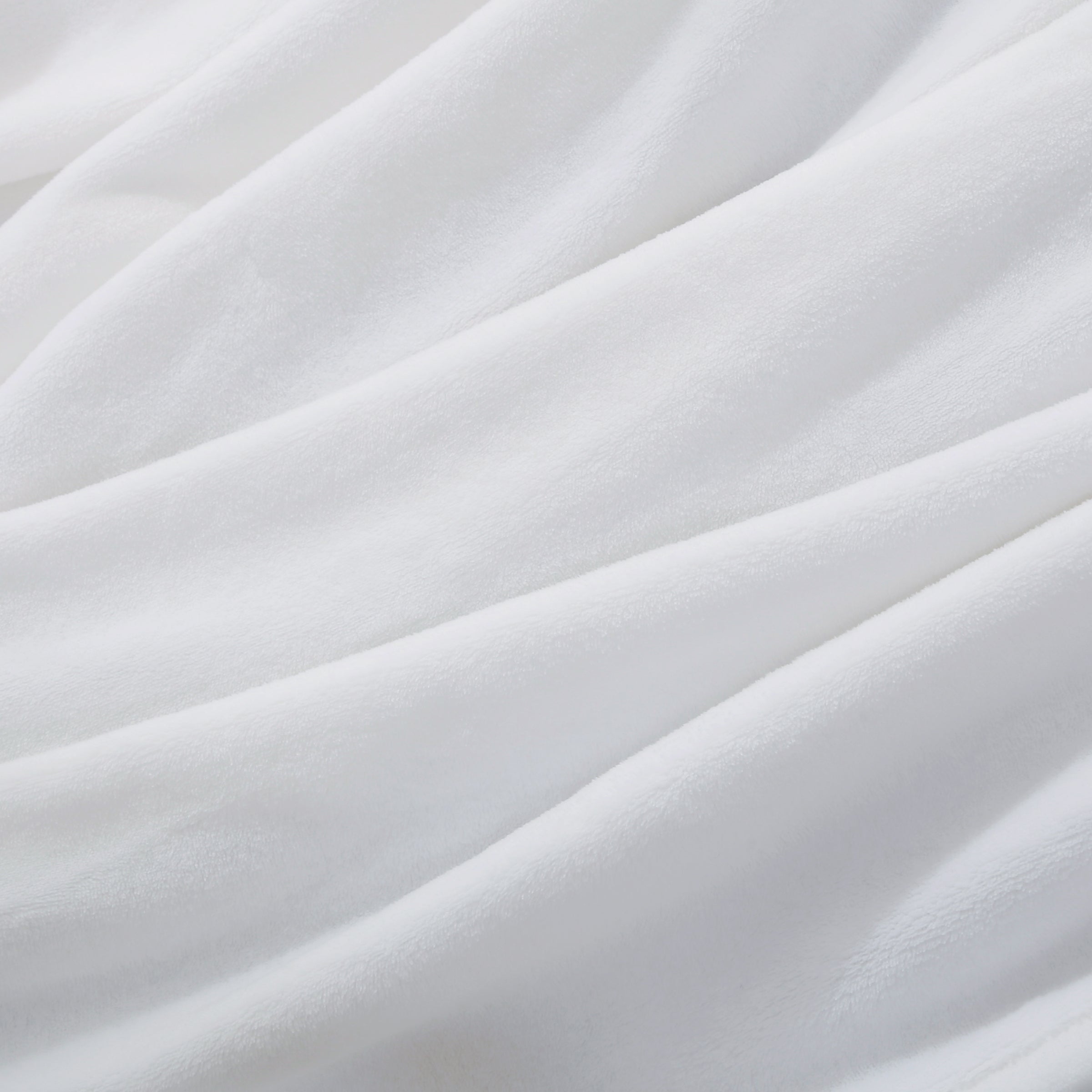 A close up of a white velvety plush throw displaying its silky smooth texture.