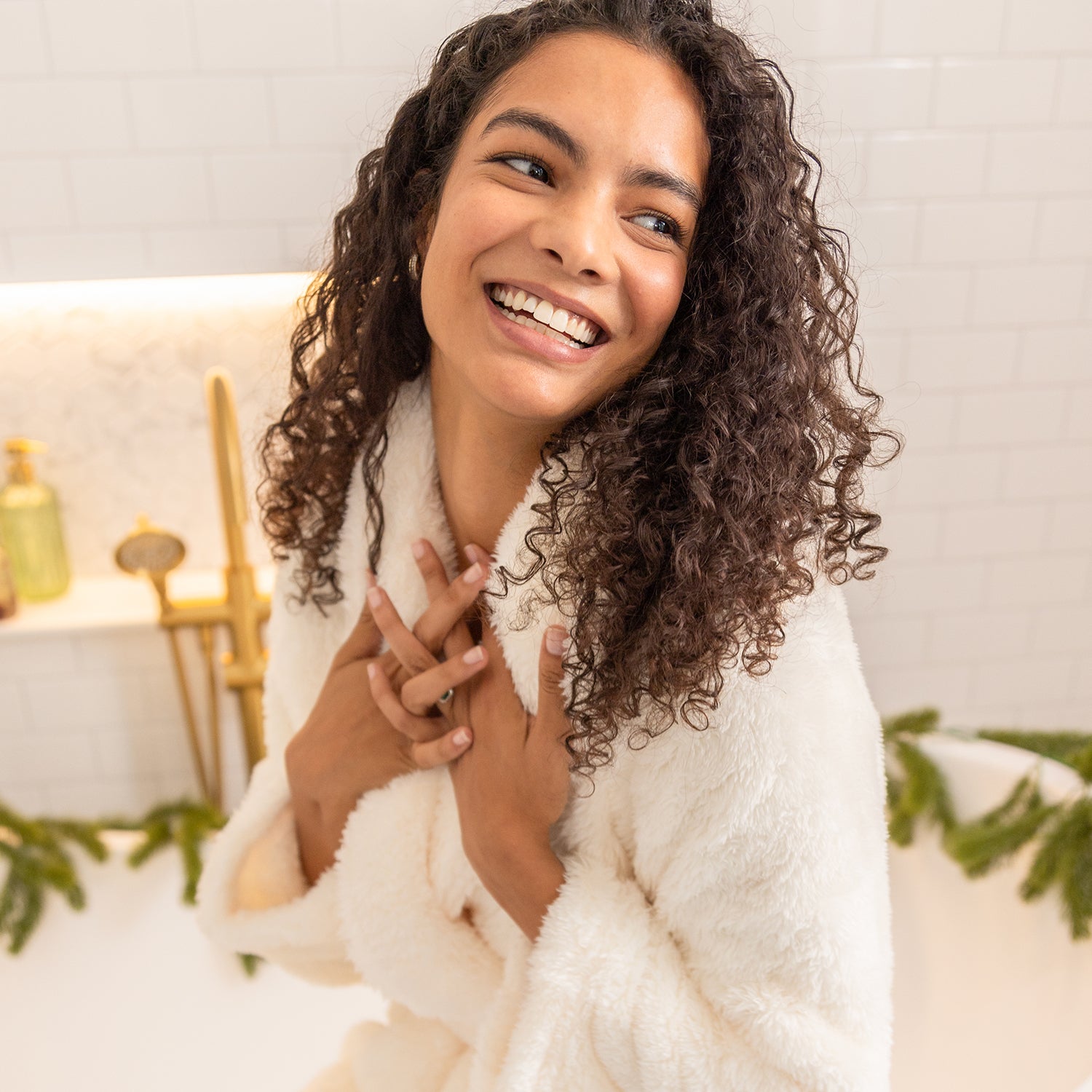 Woman wrapped in a white robe with a blurred indoor background