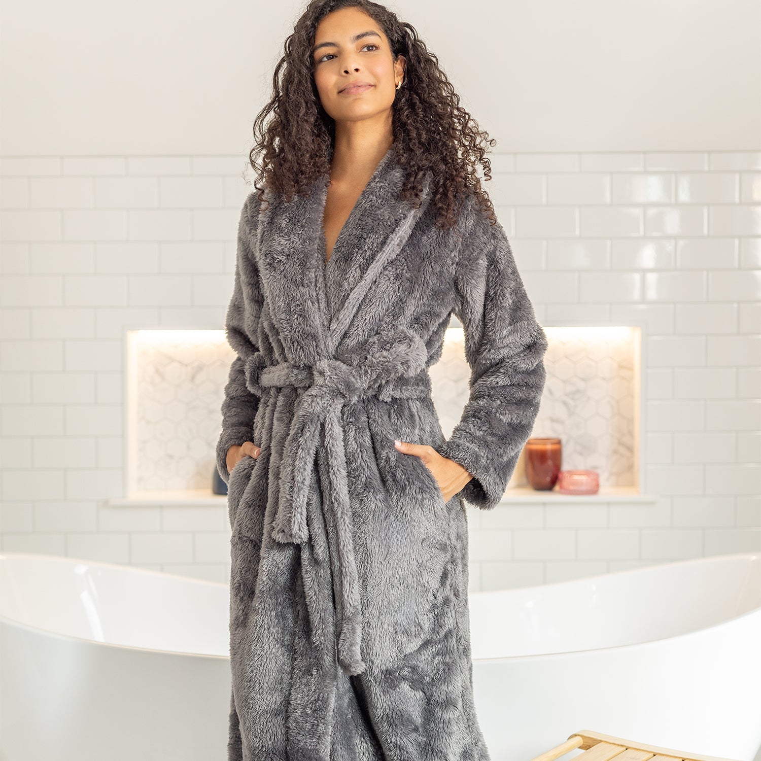 Woman wearing a gray robe in a bathroom setting