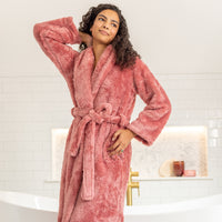 Woman wearing a pink robe in a bathroom setting