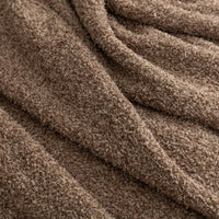 Close up of the fabric on a brown throw.