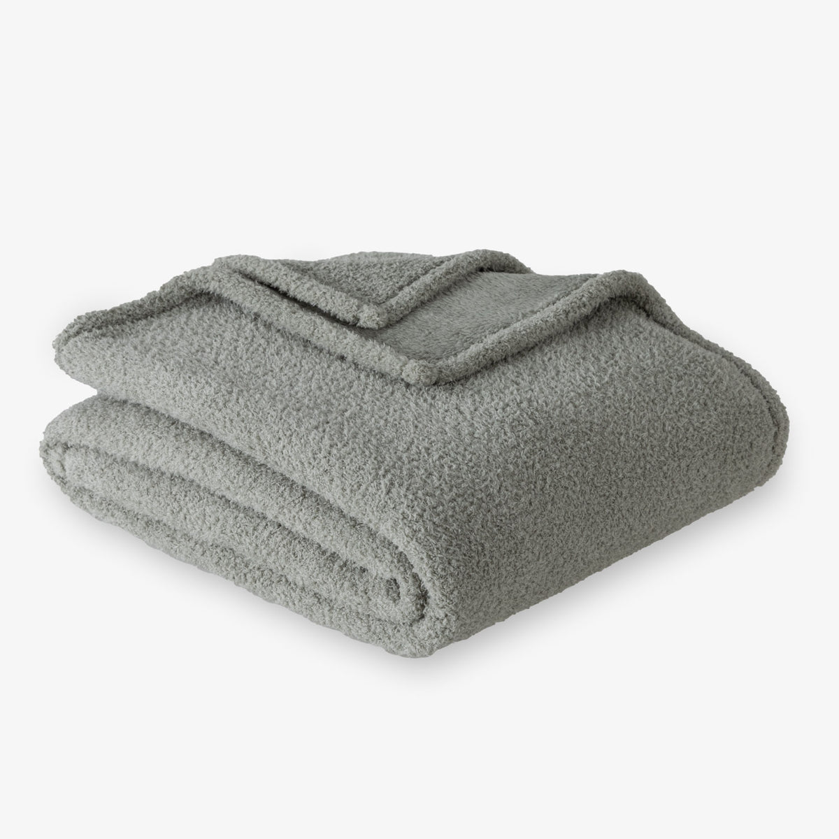 Folded green blanket on a white background