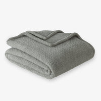Folded green blanket on a white background