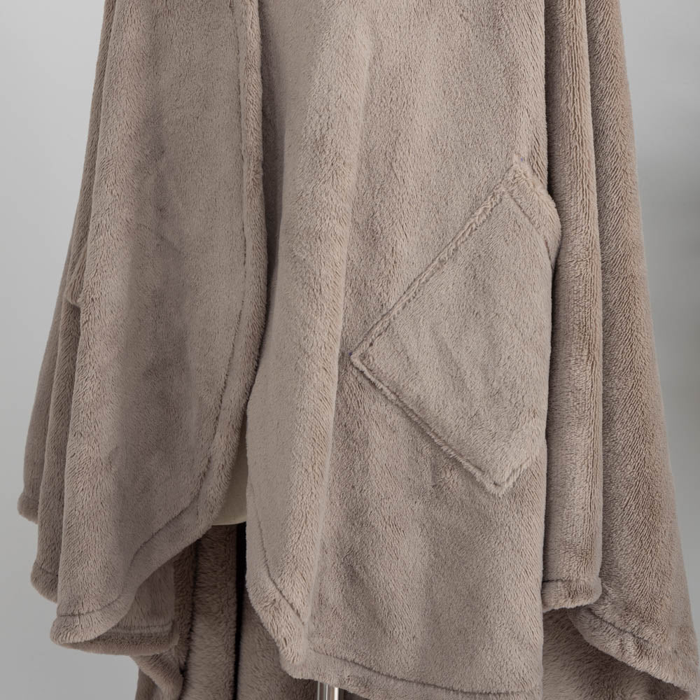A taupe PrimaLush Cape Wrap displayed on a mannequin in a bright, modern room.