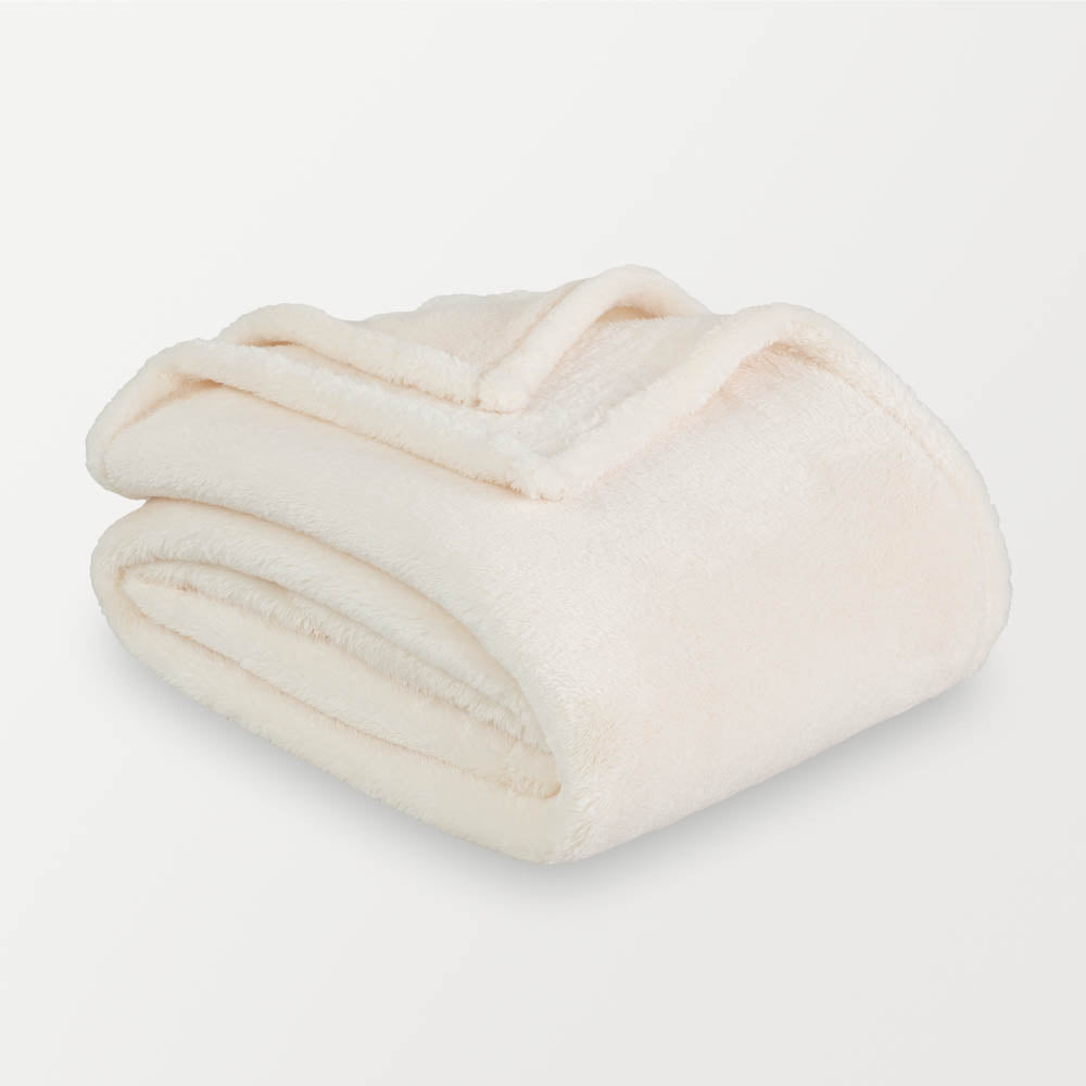 A white fluffy blanket folded neatly on a white surface.