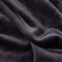 Close up of a black velvety plush family blanket displaying its silky smooth texture.