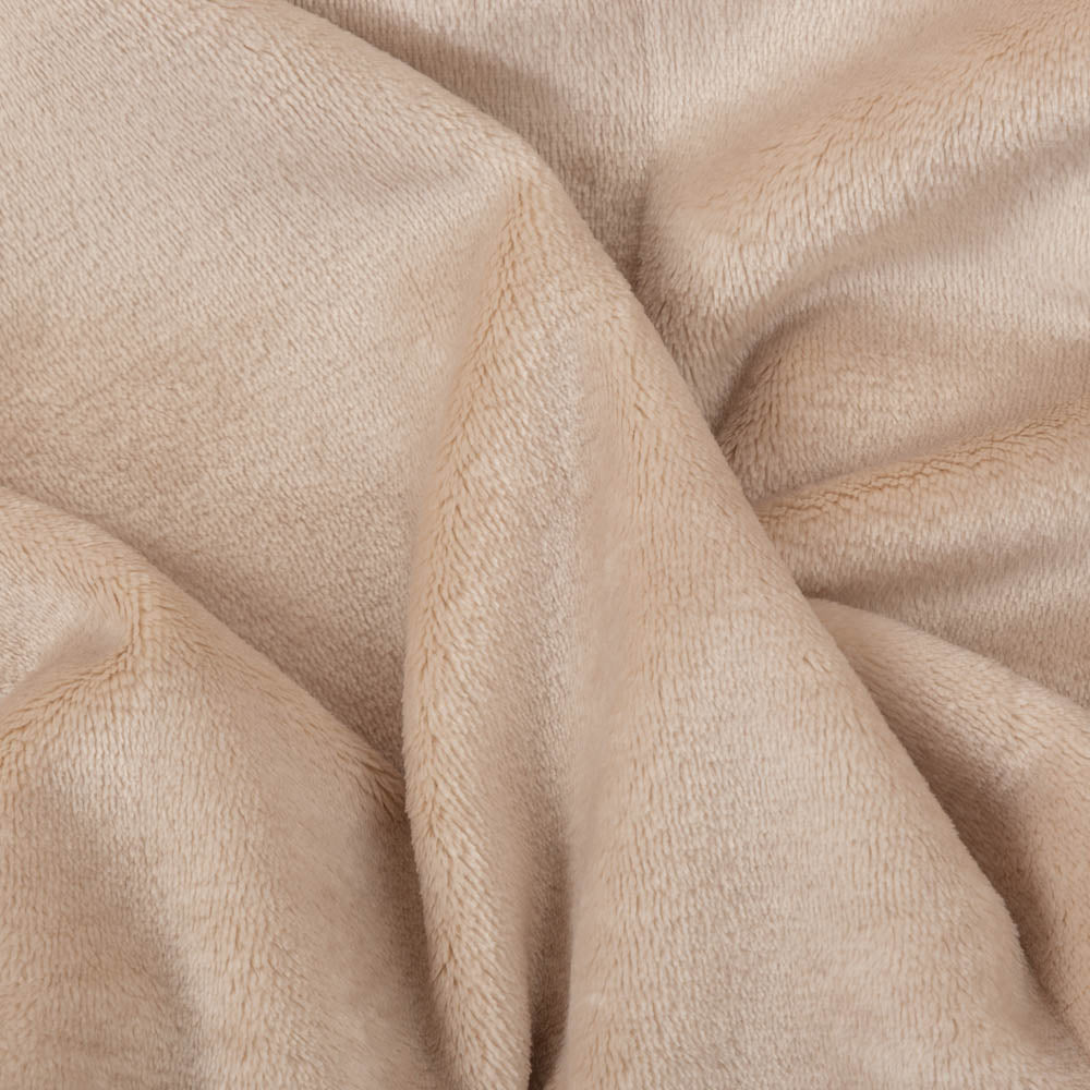 Close up of a beige velvety plush family blanket displaying its silky smooth texture.