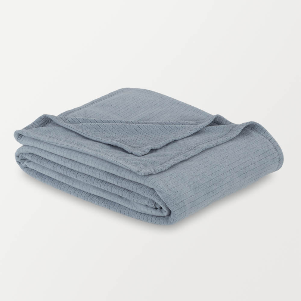 Folded polar bluePolartec blanket on a white background, highlighting its soft texture and design.