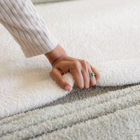 Person's hand touching a textured white surface