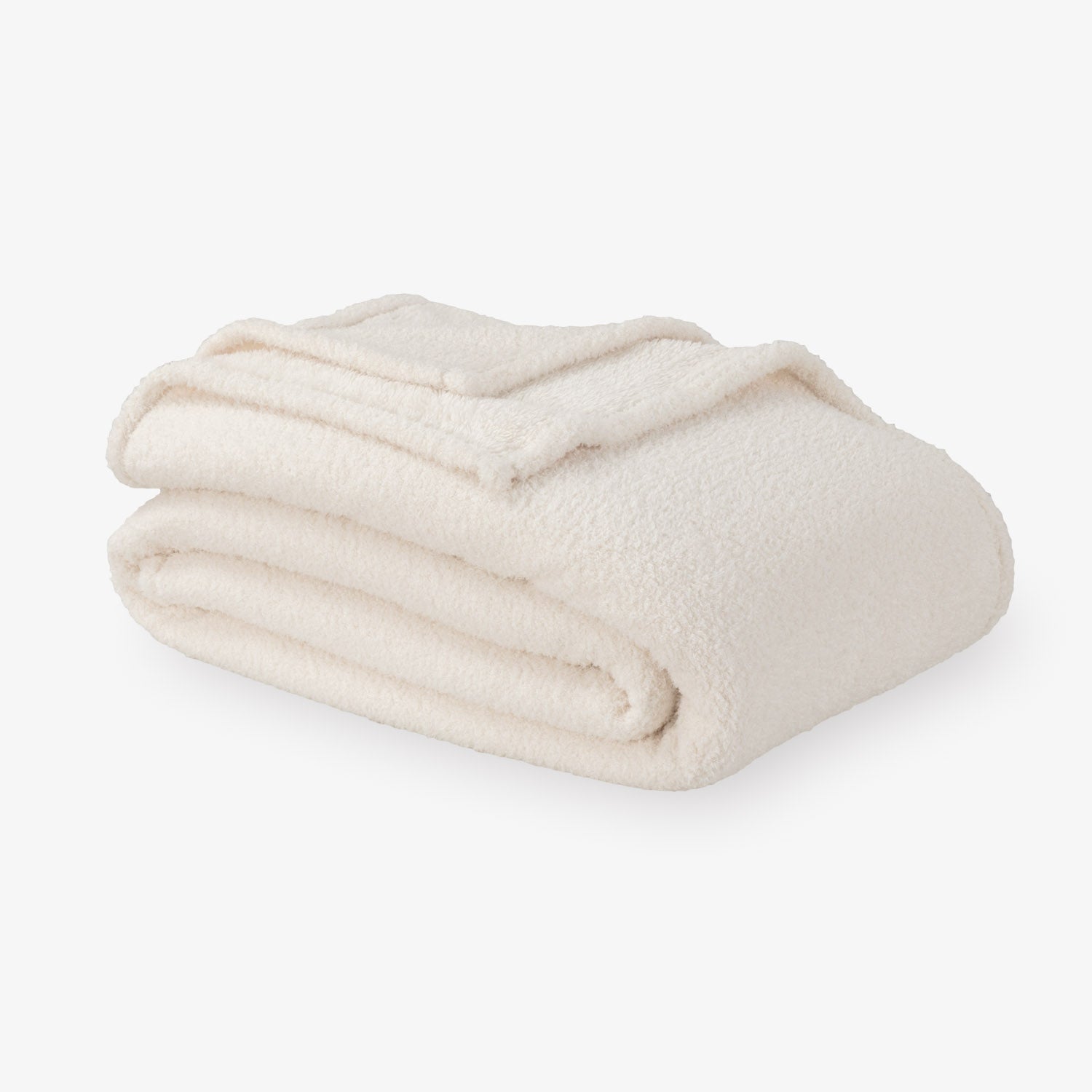 Folded beige blanket on a white background