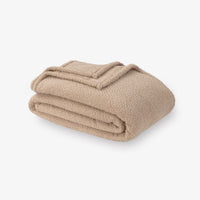 Folded beige blanket on a white background