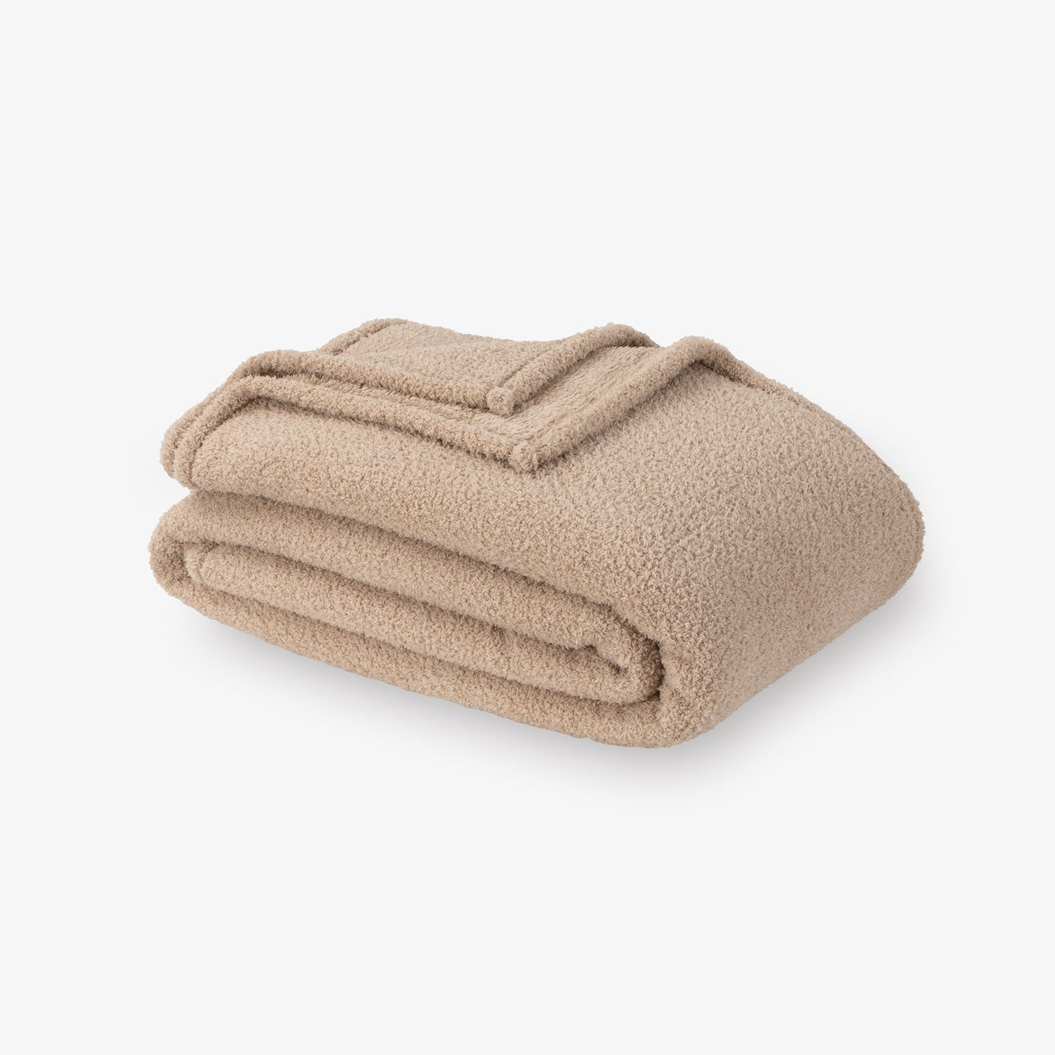 Folded beige blanket on a white background