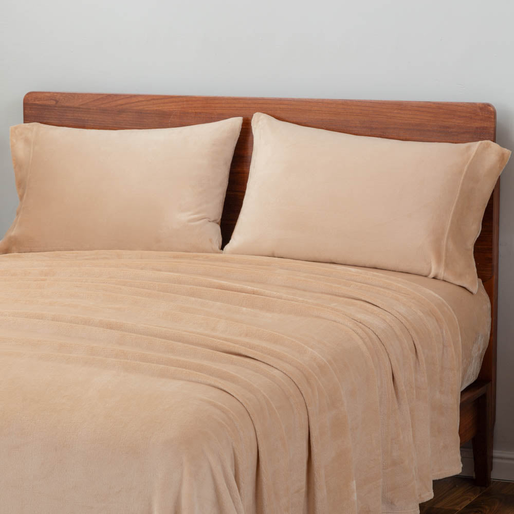 Aruba Sand sheet set styled with two pillows on a bed.