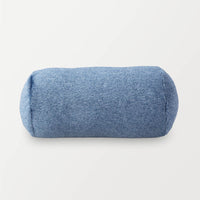 A blue EcoThread Neckroll Pillow sitting on a white surface.
