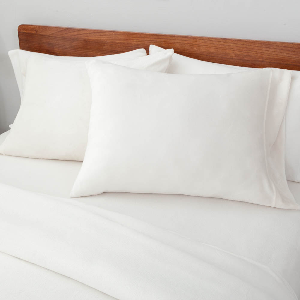Close-up view of the Cream VelvetLoft® pillow sham and duvet cover on the bed, highlighting their plush softness and finish.