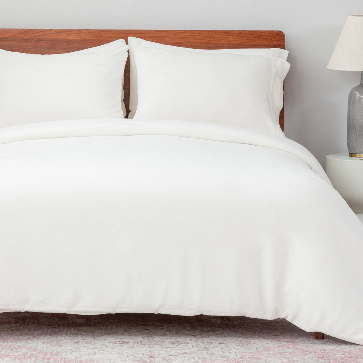 VelvetLoft® Duvet Set in Cream on a made bed with a wooden headboard, angled view