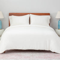 A bed made with the Cream VelvetLoft® Plush Duvet Cover Set and shams, creating a cozy and inviting look. 