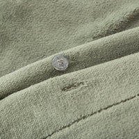 Close-up of the Dark Sage Green VelvetLoft® fabric and button closure of the duvet set, highlighting its plush, silky texture.