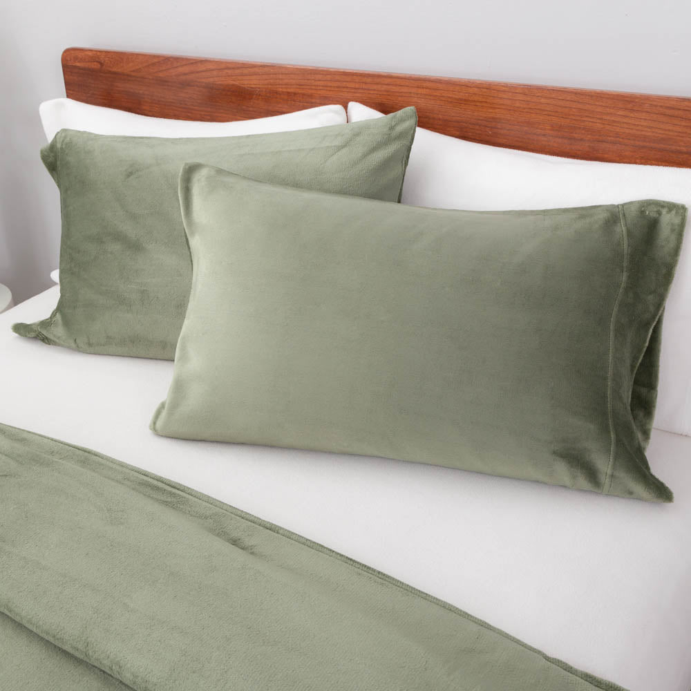 Close-up view of the Dark Sage green VelvetLoft® pillow sham and duvet cover on the bed, highlighting their plush softness and finish.