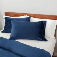 Close-up view of the Dress Blue VelvetLoft® pillow sham and duvet cover on the bed, highlighting their plush softness and finish.