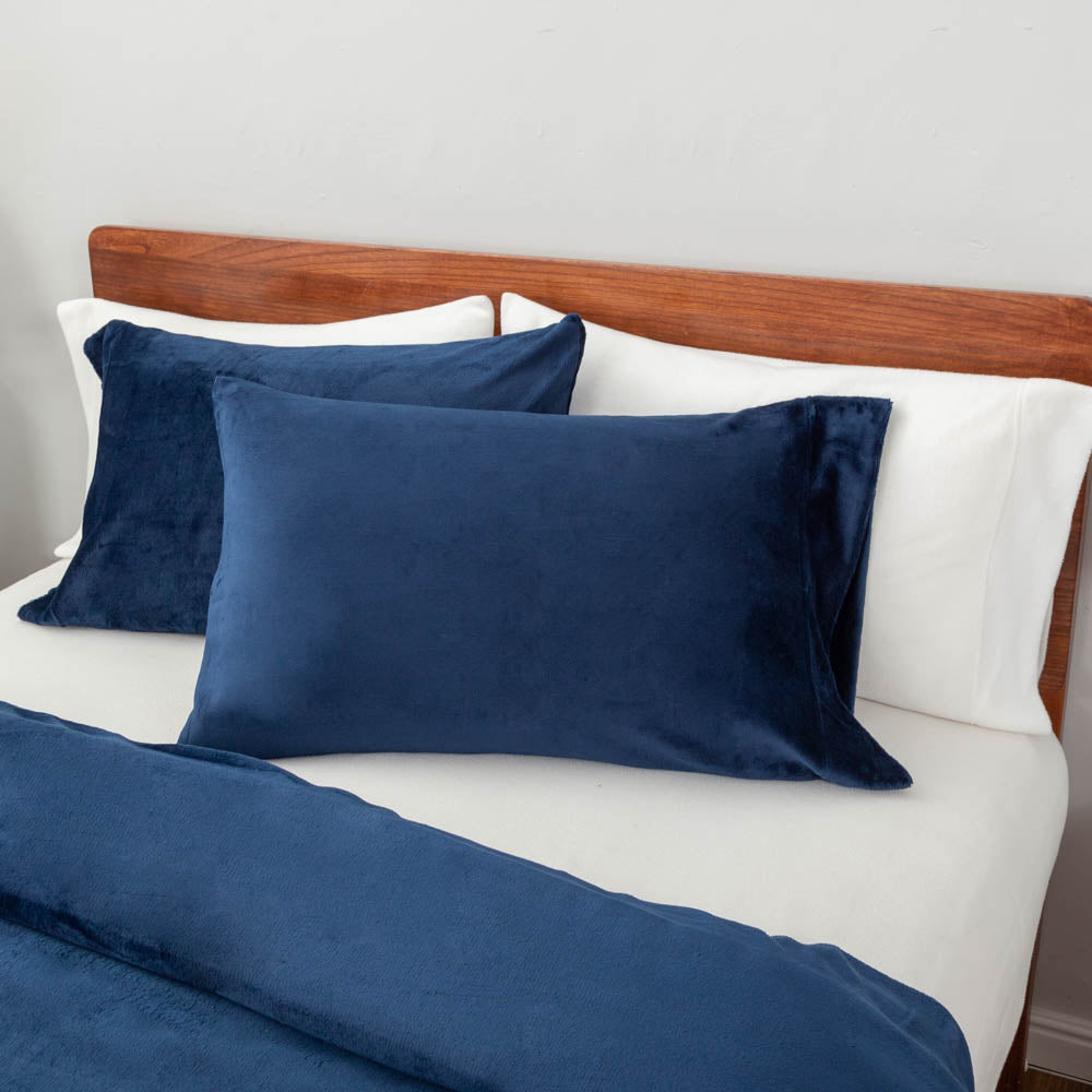 Close-up view of the Dress Blue VelvetLoft® pillow sham and duvet cover on the bed, highlighting their plush softness and finish.