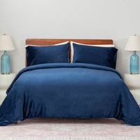 A bed made with the Dress Blue  VelvetLoft® Plush Duvet Cover Set and shams, creating a cozy and inviting look. 