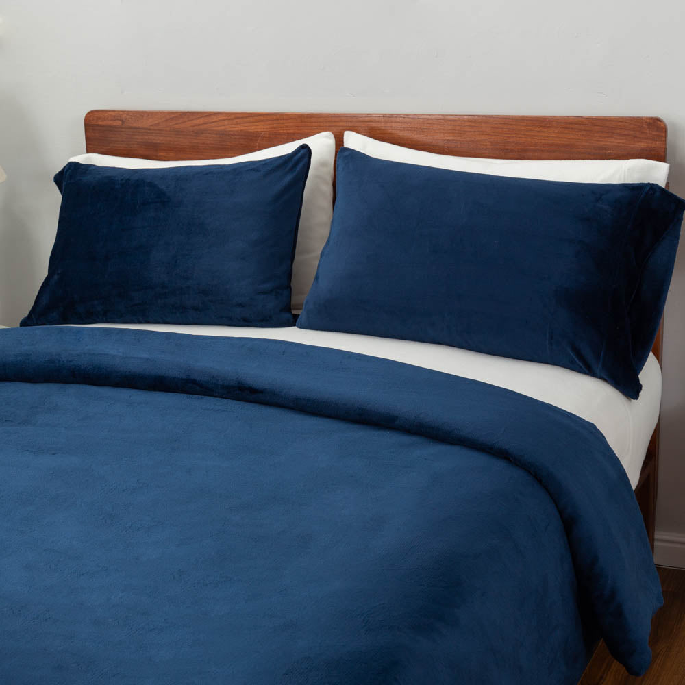 A bed styled with the VelvetLoft® Plush Duvet Cover Set, featuring two large pillow shams and the duvet cover neatly draped.