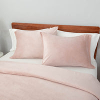Close-up view of the Rose Smoke VelvetLoft® pillow sham and duvet cover on the bed, highlighting their plush softness and finish.