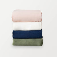 Stack of VelvetLoft® duvet covers, from top to bottom: rose smoke, cream, dress blue, dark sage