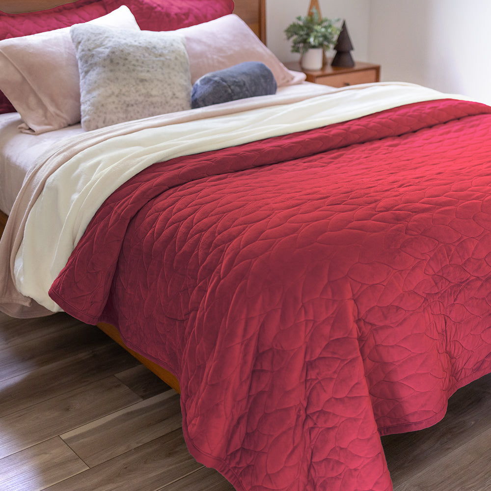Red quilt set decorated on a bed.